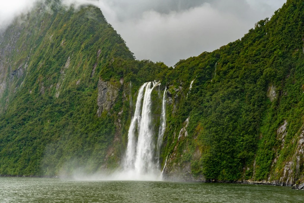 Stirling Falls plunging into Milford Sound Fiordland rainforest cliff walls